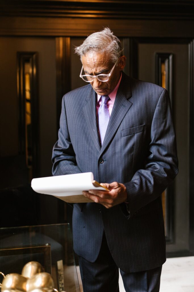 A Man in Blue Suit Reading a Document